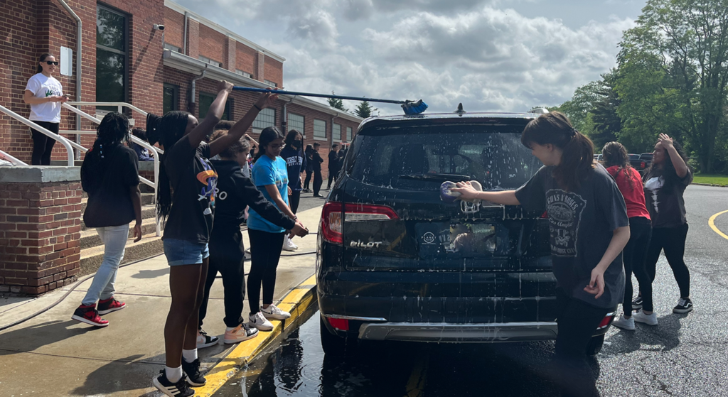 Middle School Students participating in the Day of Service by providing a car wash.  All proceeds will go to fighting childhood cancer. 