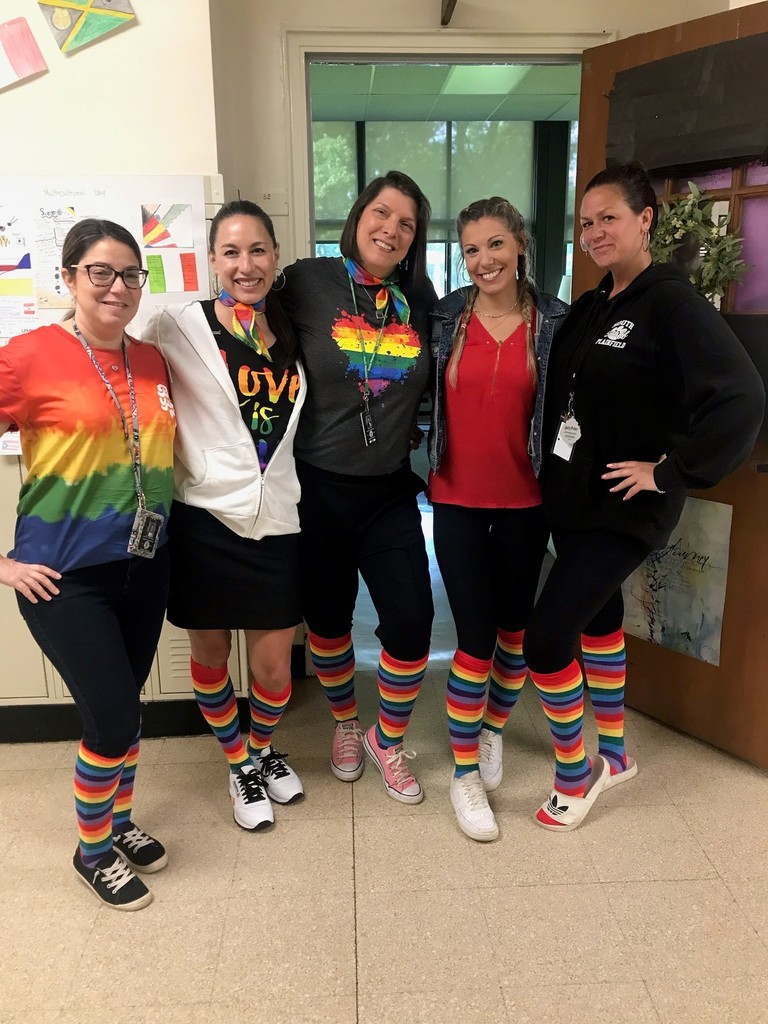 Teachers posing with rainbow socks to celebrate pride month
