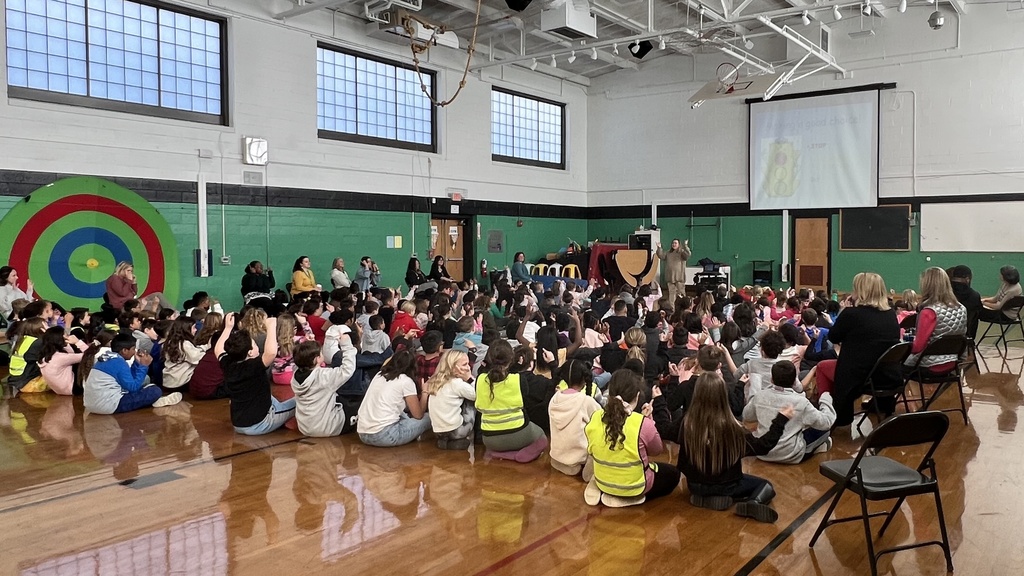 schoolwide assembly kids sitting on floor